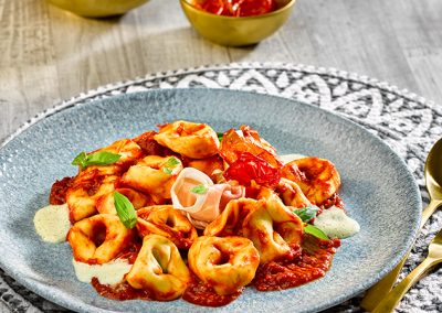 Bio Tortelloni Spinat-Ricotta mit Kirschtomaten und Balsamico-Sauce auf Parmesanschaum
